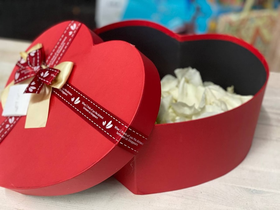 Лепестки белых и красных роз в коробке